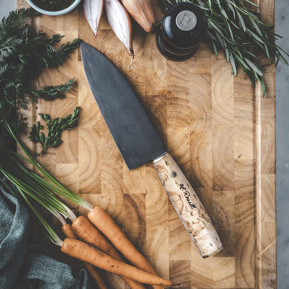 Roselli's Finnish handmade Japanese kitchen knife in model "Santoku knife". Made from carbon steel and curly birch. Comes with a handmade sheath of light vegetable Finnish leather.